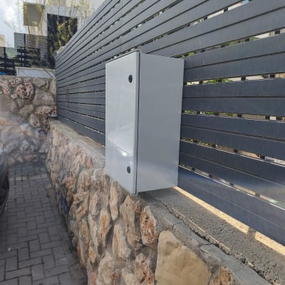 ארון חשמל מותקן על גדר אבן בחוץ