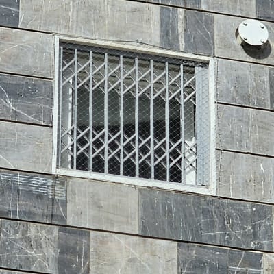 חלון עם סורגים על קיר אבן אפור