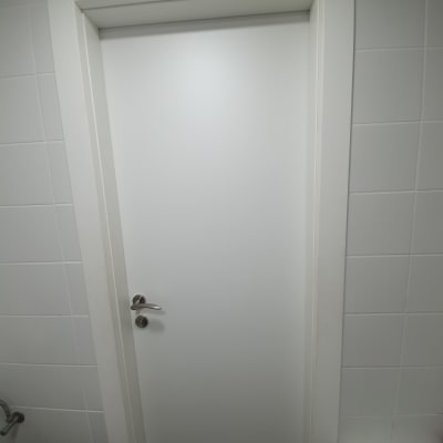 דלת לבנה עם ידית מתכת בחדר אמבטיה