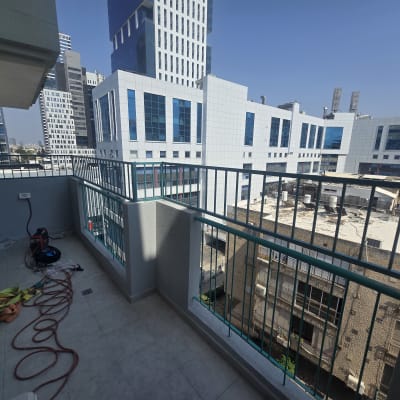 מרפסת עם נוף לבניינים גבוהים וחפצים על הרצפה