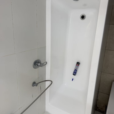 אמבטיה לבנה עם ברז וצינור מתכת