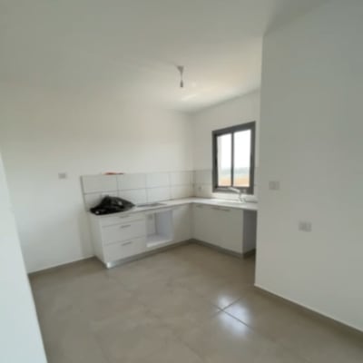 מטבח חדש עם ארונות לבנים ומשטח עבודה