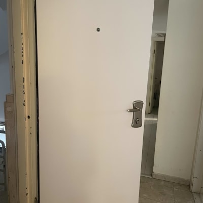 דלת לבנה עם ידית מתכת ומנעול