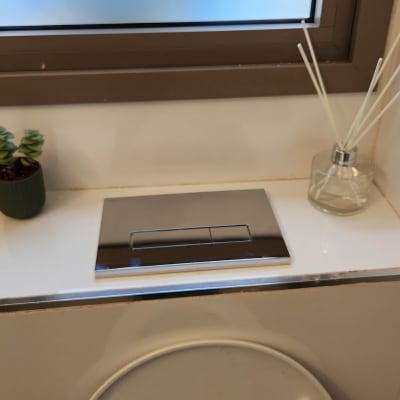 לחצן ניאגרה כפול על קיר חדר אמבטיה