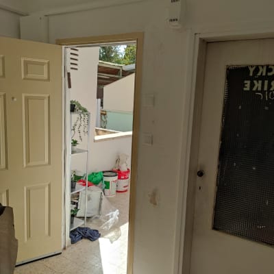 דלי צבע אדום ולבן ליד דלת פתוחה