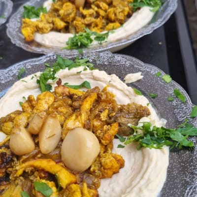 צלחות חומוס עם תוספות עוף, בצל ופטרוזיליה