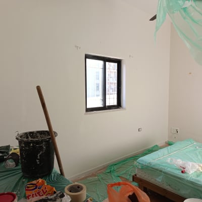 חדר עם קירות צבועים, דלי ומברשת צבע