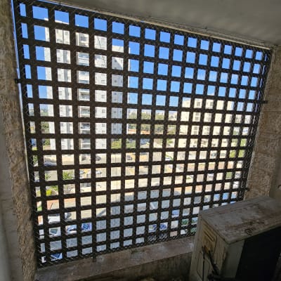 רשת מתכת על חלון למניעת כניסת יונים