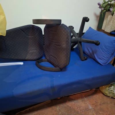 כיסא הפוך על מיטה כחולה עם כרית