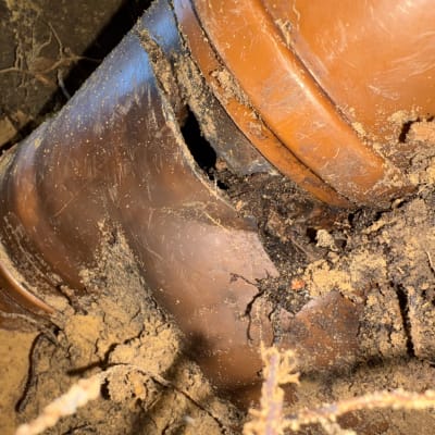 צינור שבור באדמה עם סדקים ולכלוך