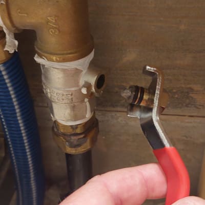 יד מחזיקה כלי עבודה ליד צינור מתכת