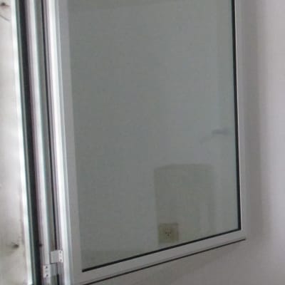 חלון אלומיניום פתוח על קיר לבן