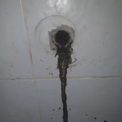 צינור עם נזילה על קיר אריחים