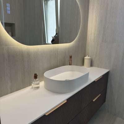 חדר אמבטיה מעוצב עם כיור ומראה מוארת