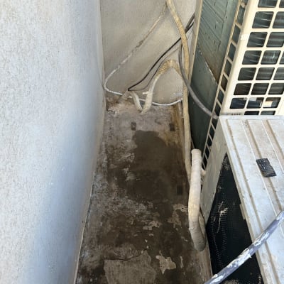 צינורות מבודדים ליד יחידת מיזוג אוויר על רצפה רטובה