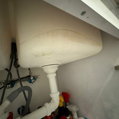 כיור עם צנרת פלסטיק מתחת לארון מטבח