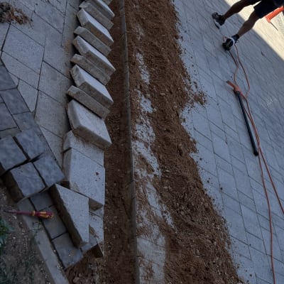 שני אנשים עובדים על חפירת תעלה במדרכה