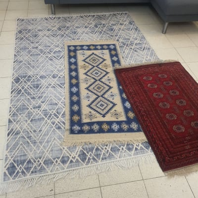 שטיחים צבעוניים על רצפת אריחים ליד ספה אפורה
