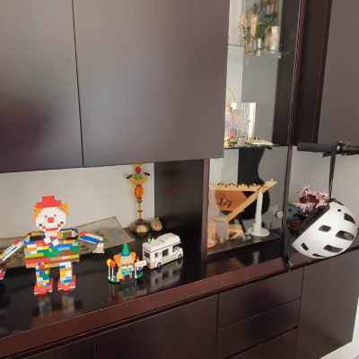 קסדה תלויה על קורקינט ליד ארון עם צעצועים