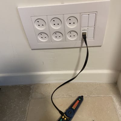 כבל רשת מחובר לשקע עם בודק כבלים על הרצפה