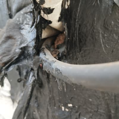 חומר איטום שחור על גג עם צינור חשוף