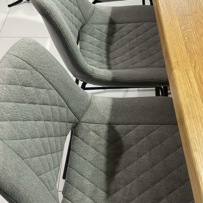 כיסאות מרופדים אפורים ליד שולחן עץ