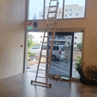 סולם גבוה ליד חלון עם חוטי חשמל