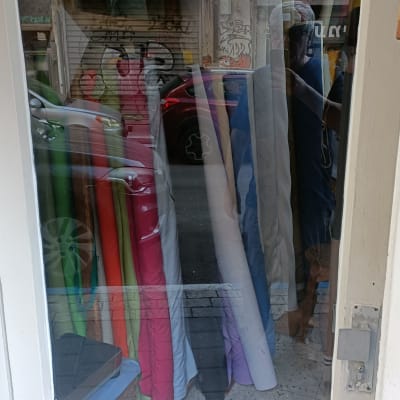 השתקפות חלון עם בדים צבעוניים מאחוריו