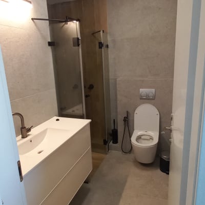 חדר אמבטיה עם כיור, אסלה ומקלחון זכוכית