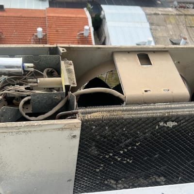 יחידת מזגן חיצונית עם חלקים חשופים על גג בניין