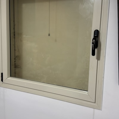 חלון עם מסגרת לבנה וקיר לבן