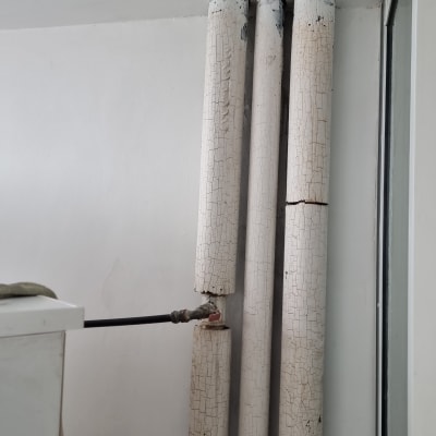 צינורות ישנים עם צבע מתקלף על קיר