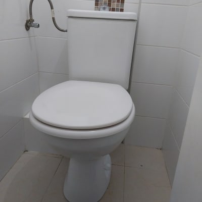 אסלה עם צינור מים מחובר לקיר