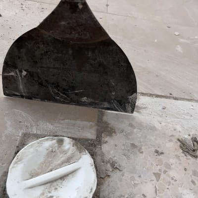 כלי מתכת על רצפה עם אריחים ואבק