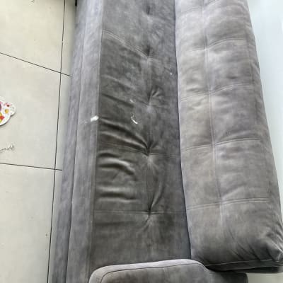 ספה אפורה עם כתמים על הרצפה