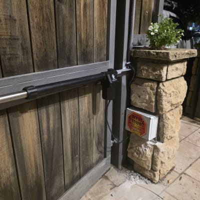 שער חשמלי עם מנוע מותקן על עמוד אבן