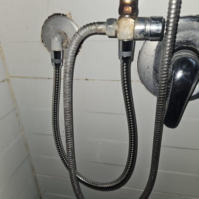 צינורות מתכת ומחברים על קיר לבן