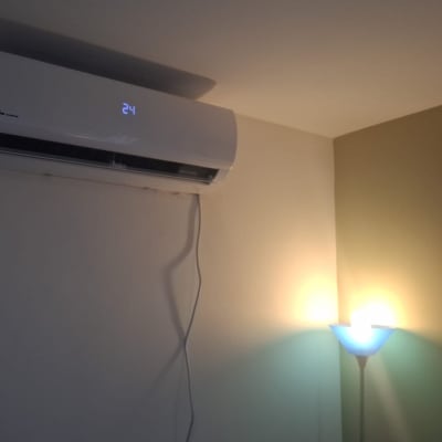 מזגן מותקן על קיר עם מנורה ושעון