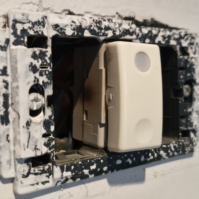 מתג חשמלי בקיר עם מסגרת פגומה