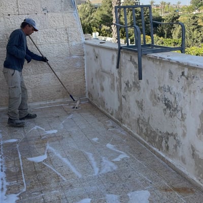 אדם מנקה מרפסת עם רולר וסבון
