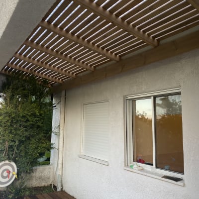 פרגולה מעץ מעל חלון וגינה