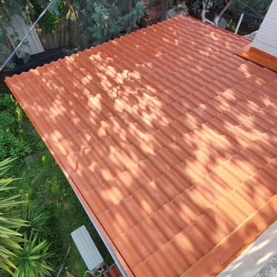 גג רעפים כתום עם צללים מעצים סמוכים