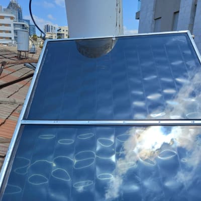 קולטי שמש על גג רעפים עם שמיים בהירים