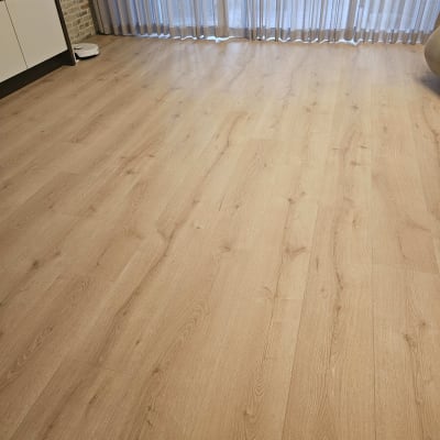 רצפת פרקט עץ בהירה בחדר עם וילונות