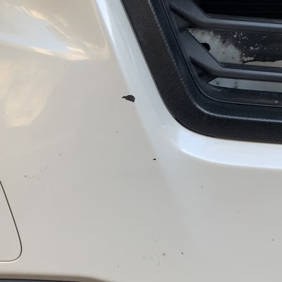 פגוש רכב לבן עם שריטות ופגמים קטנים
