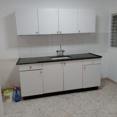 ארונות מטבח עם חומרי ניקוי על הרצפה