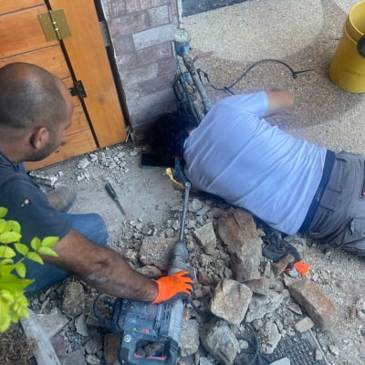 שני אנשים עובדים על תיקון נזילה עם כלים וחומרים