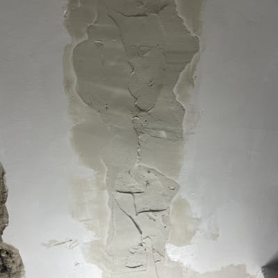 תיקון טיח על קיר עם שכבות צבע שונות