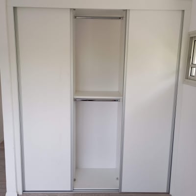 ארון בגדים לבן עם דלתות הזזה ומוט תלייה