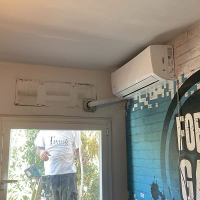 מזגן מותקן על קיר עם צינור חיצוני